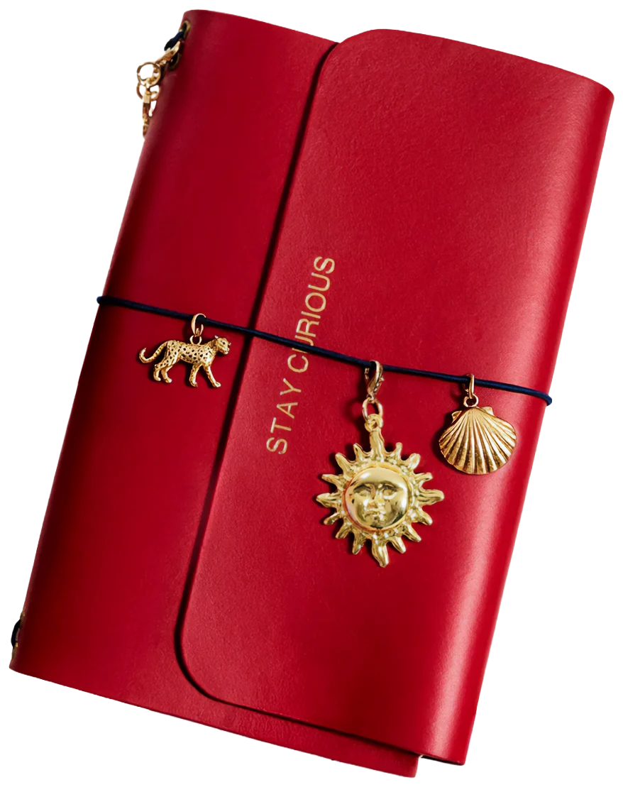 Red leather journal with leopard, sun and shell charms on a navy cord
